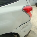 Before and after photographs of a damaged white Subaru that was repaired by Elite Paint & Body Shop in West Palm Beach, Florida